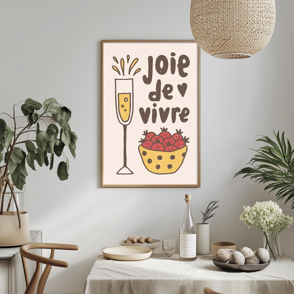 a dining table with a bowl of fruit, a wine glass, and a plant, along with a framed poster on the wall that says "Joie de vivre".