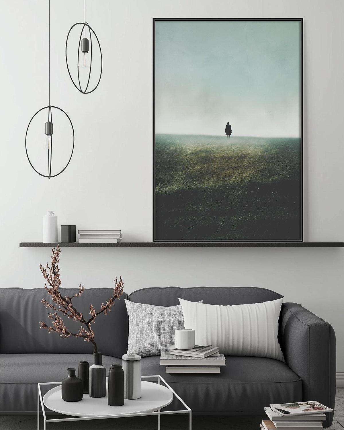 a modern living room with a gray sofa, a coffee table, and a large framed landscape painting depicting a person standing in a field.