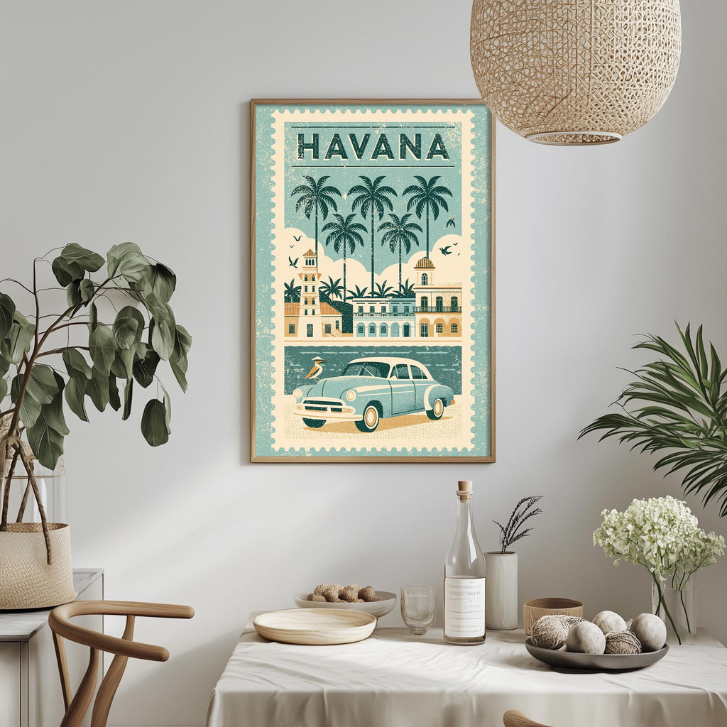 a framed vintage-style poster of Havana, Cuba, hanging on a wall above a dining table. The poster depicts a car driving down a street lined with palm trees, surrounded by buildings and other elements characteristic of Havana's tropical atmosphere.