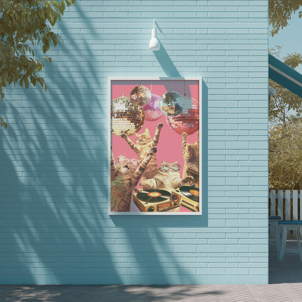 A framed collage of cats playing with disco balls on a wall, with a pink background and a white light fixture above.