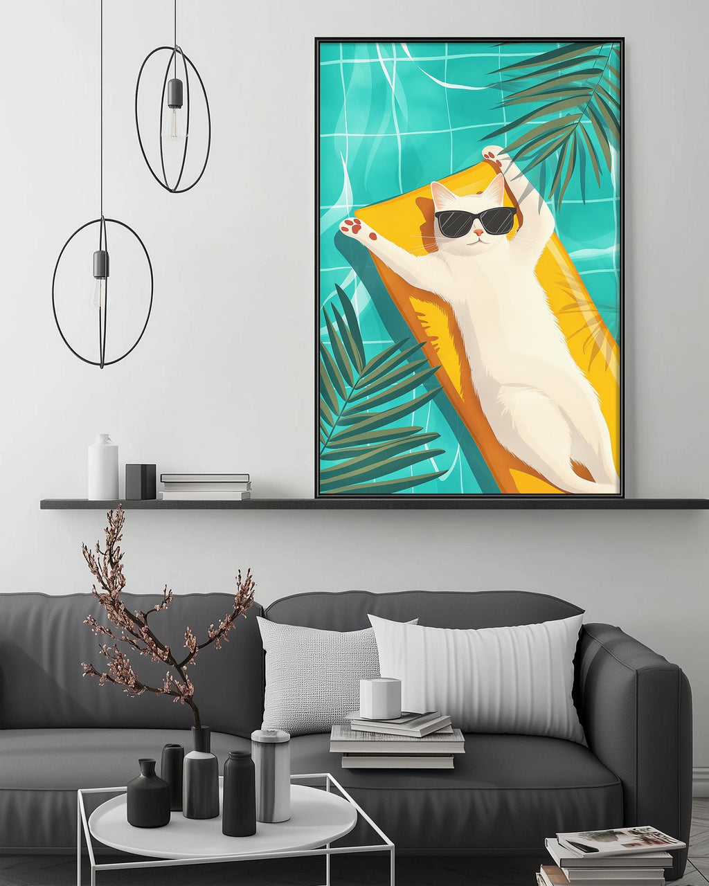 A framed illustration of a cat lounging on a beach towel, wearing sunglasses, is displayed on the wall above a gray couch in a modern living room setting.