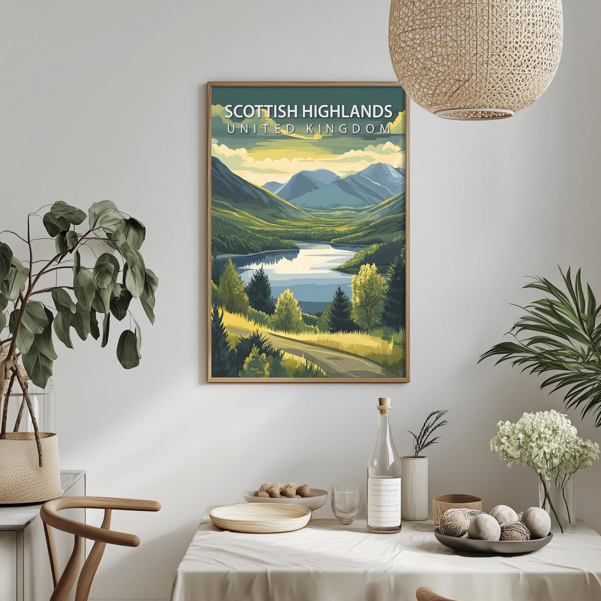 a framed poster of a scenic landscape with mountains, a lake, and a road, hanging on a wall above a dining table with various items on it.