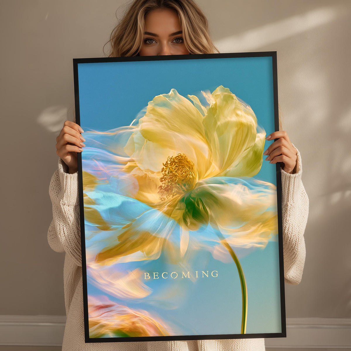 A woman holds up a framed photograph of a large, vibrant yellow flower against a blue sky background.