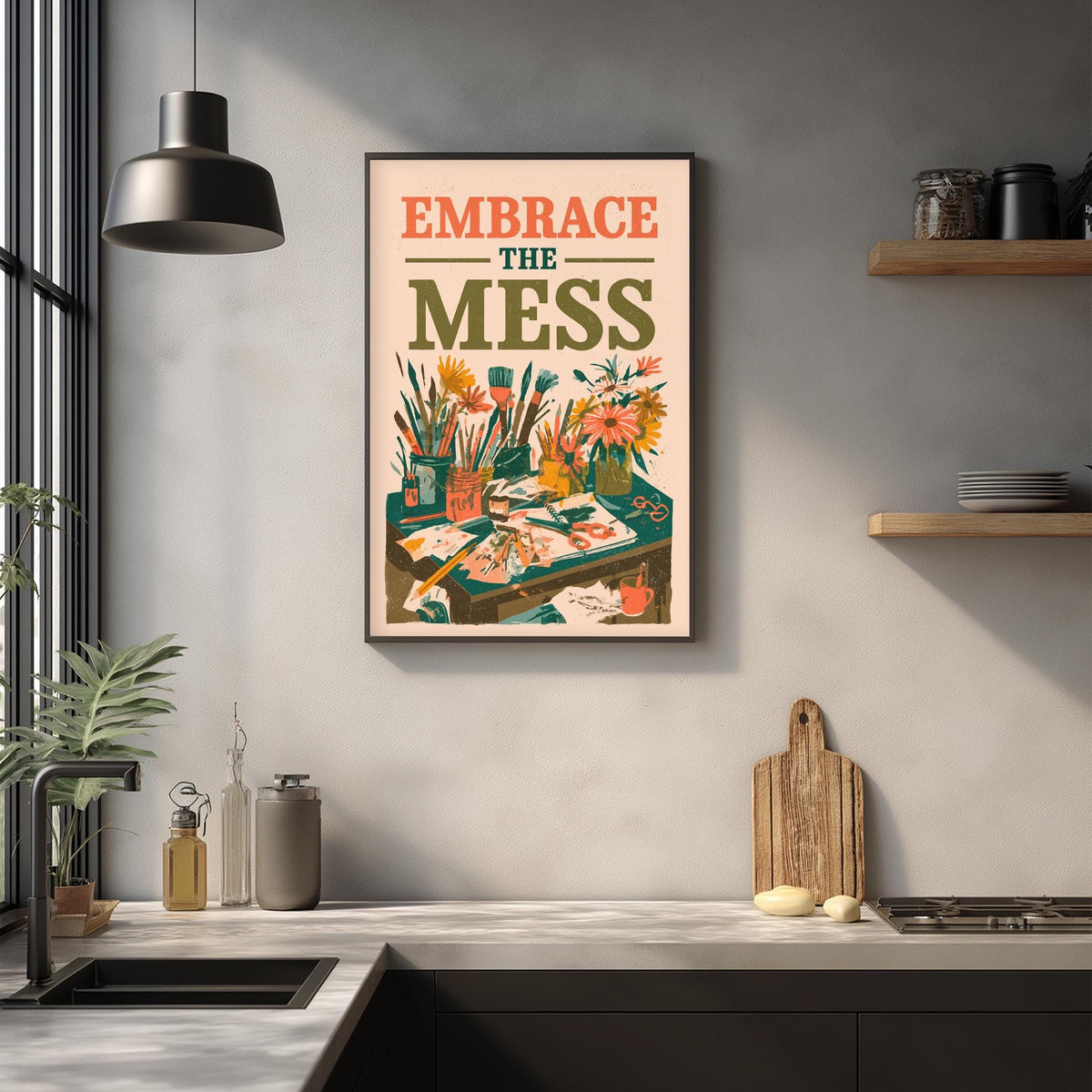 a kitchen counter with various items such as a cutting board, a soap dispenser, and a plant. Above the counter, there is a framed poster with the text "Embrace the mess" and an illustration of a cluttered workspace.