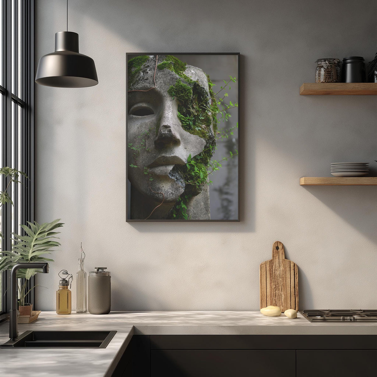 a kitchen counter with various kitchen items, including a wooden cutting board, a sink, and a potted plant. Above the counter, there is a framed image of a stone face with moss growing on it, creating a unique and artistic display.