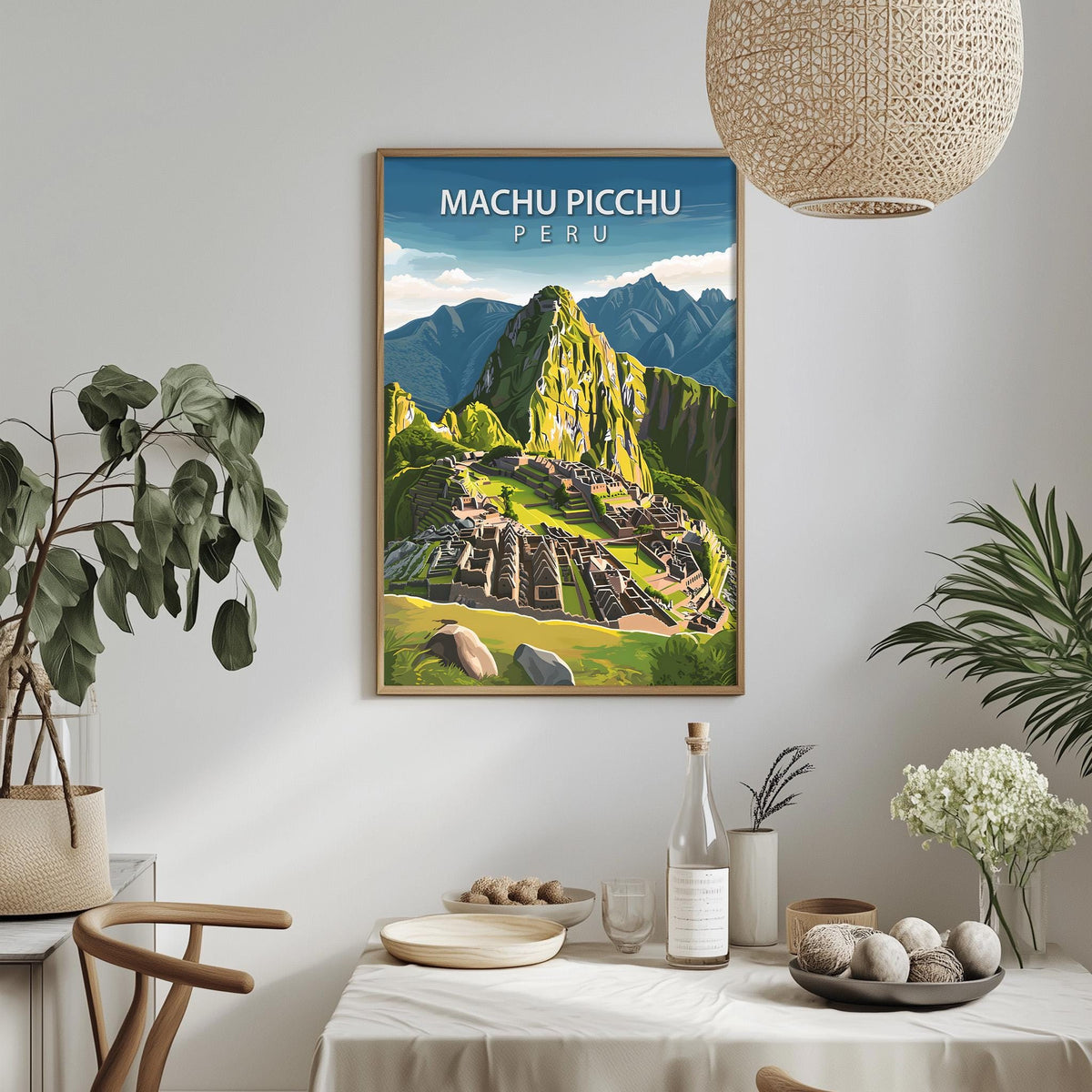 a framed poster of Machu Picchu, a famous Incan citadel located in the Andes mountains of Peru. The poster is hanging on a wall, and there is a dining table with various items on it, including a bottle, a bowl, and a vase.
