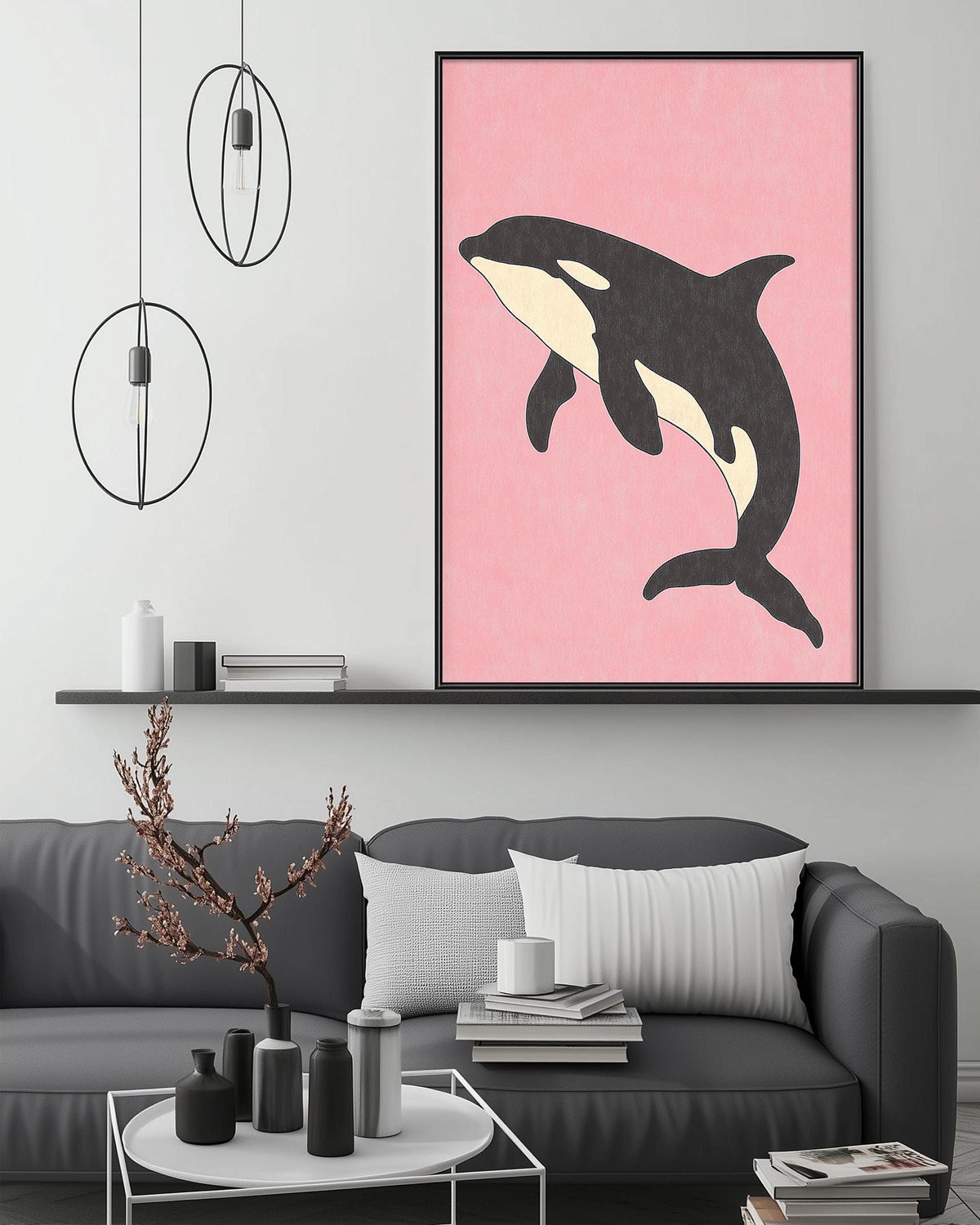 a living room with a gray couch, a coffee table, and a large framed picture of a black and white orca whale on a pink background.