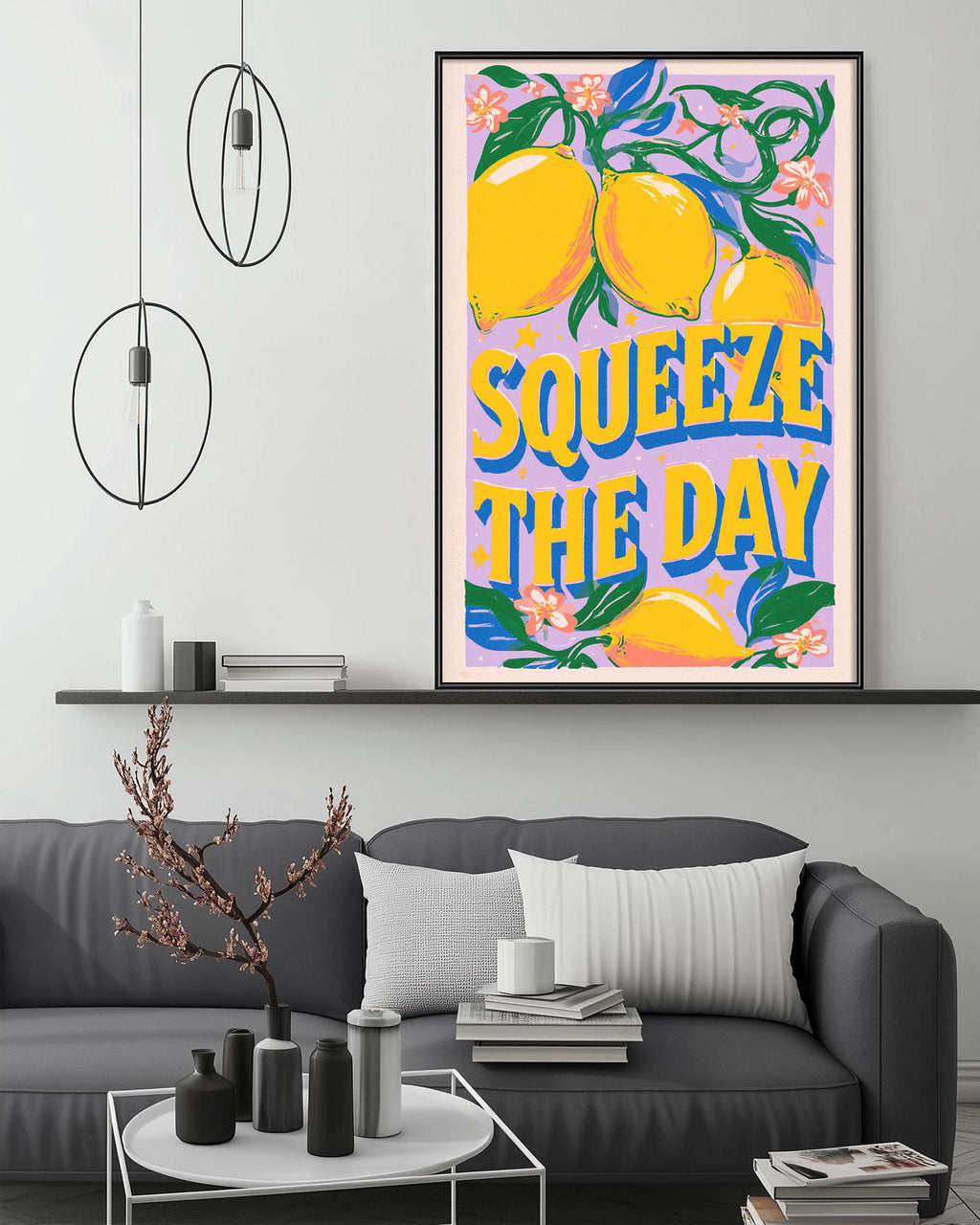 a large framed poster with a vibrant design of lemons and flowers, hanging above a gray couch in a living room setting.