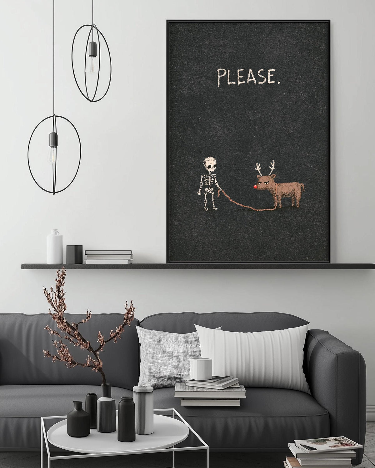 a living room with a gray sofa, a coffee table, and a large black framed poster with a skeleton and reindeer on it. The poster has the word "PLEASE" written on it.