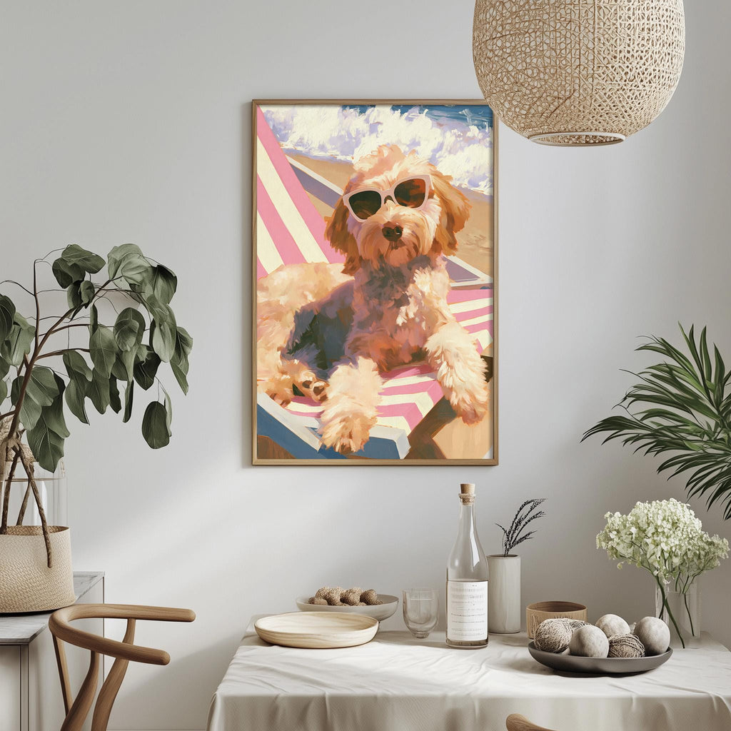 a framed painting of a dog wearing sunglasses, sitting on a beach chair, with a beach towel and potted plants in the background.
