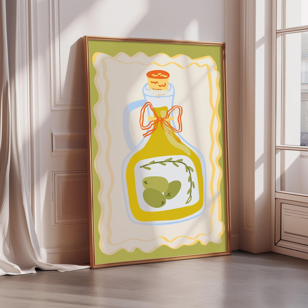 A framed illustration of a bottle of olive oil with a green olive and a red bow on top, placed on a wooden floor against a white wall.