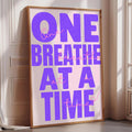 a large poster with the text "ONE BREATHE AT A TIME" in bold purple letters.