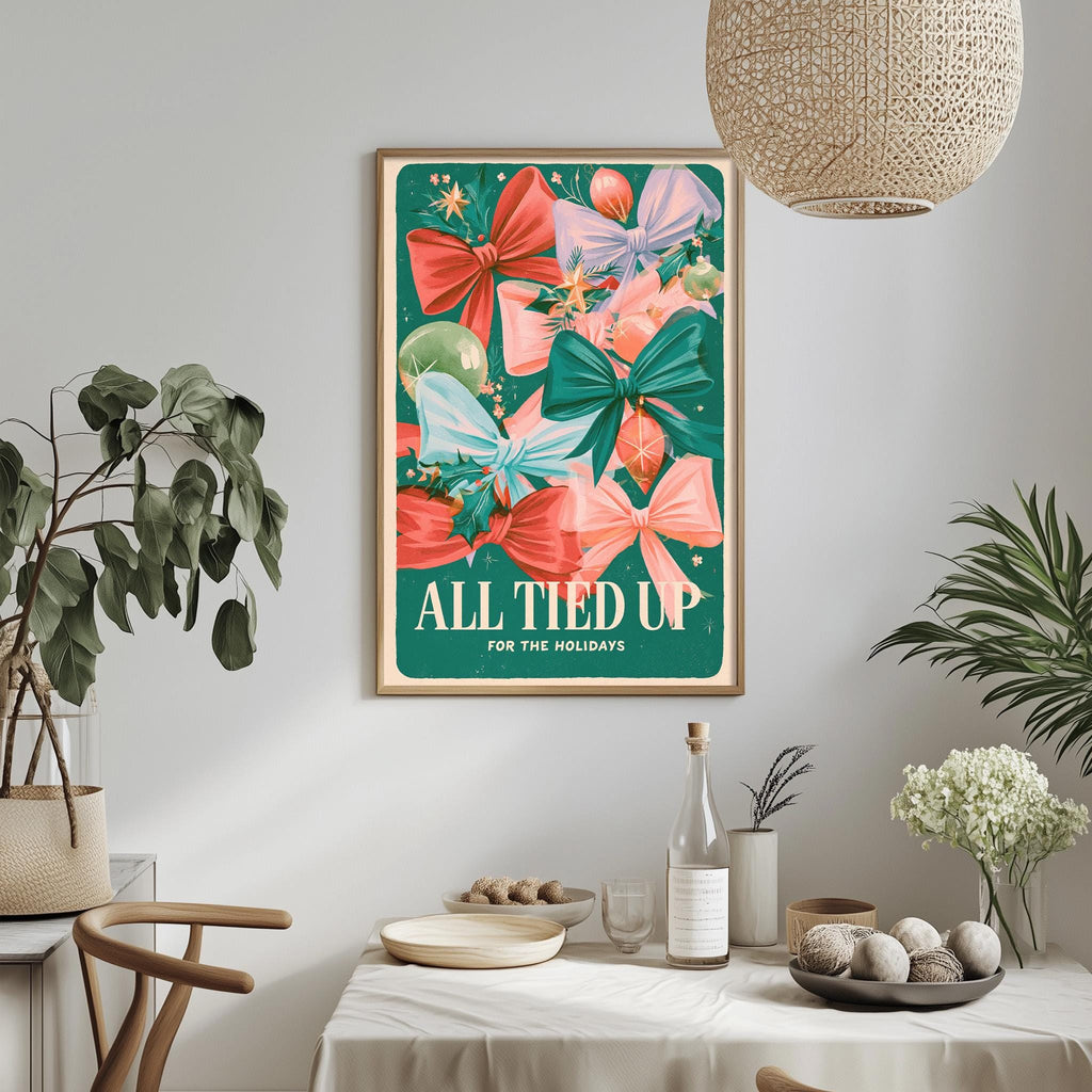 a framed poster with a colorful design of bows and flowers, hanging on a wall above a dining table with various decorative items and plants.