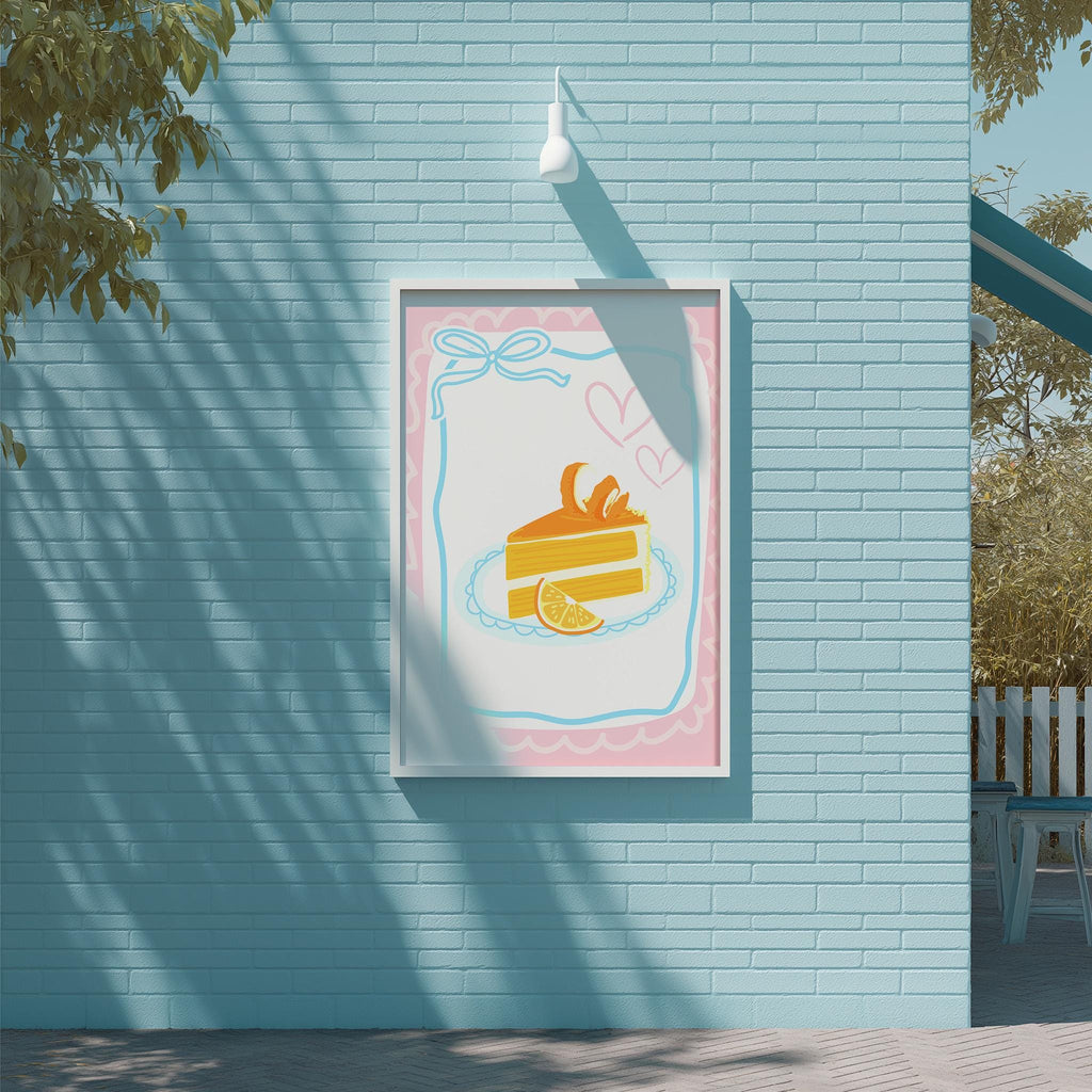 A framed illustration of a slice of cake with a heart and a slice of orange on a light blue brick wall.