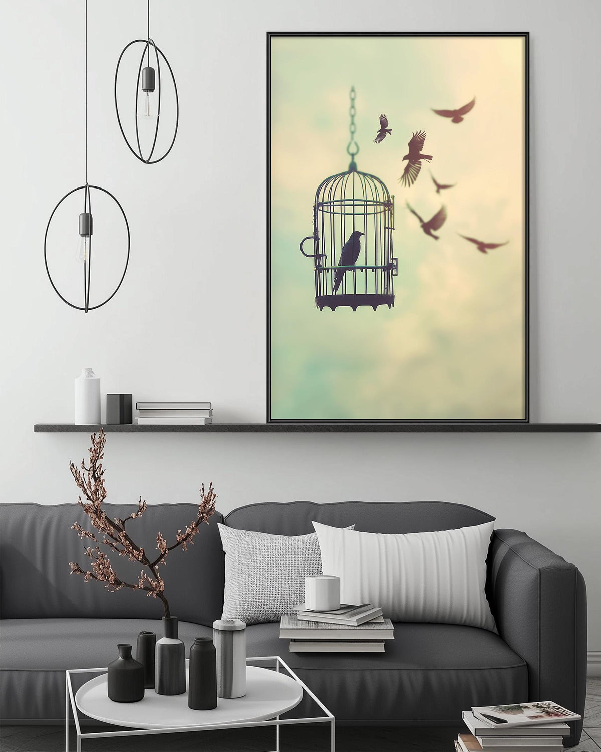 a cozy living room with a gray sofa, a coffee table, and a large framed picture of a birdcage with birds flying around it.