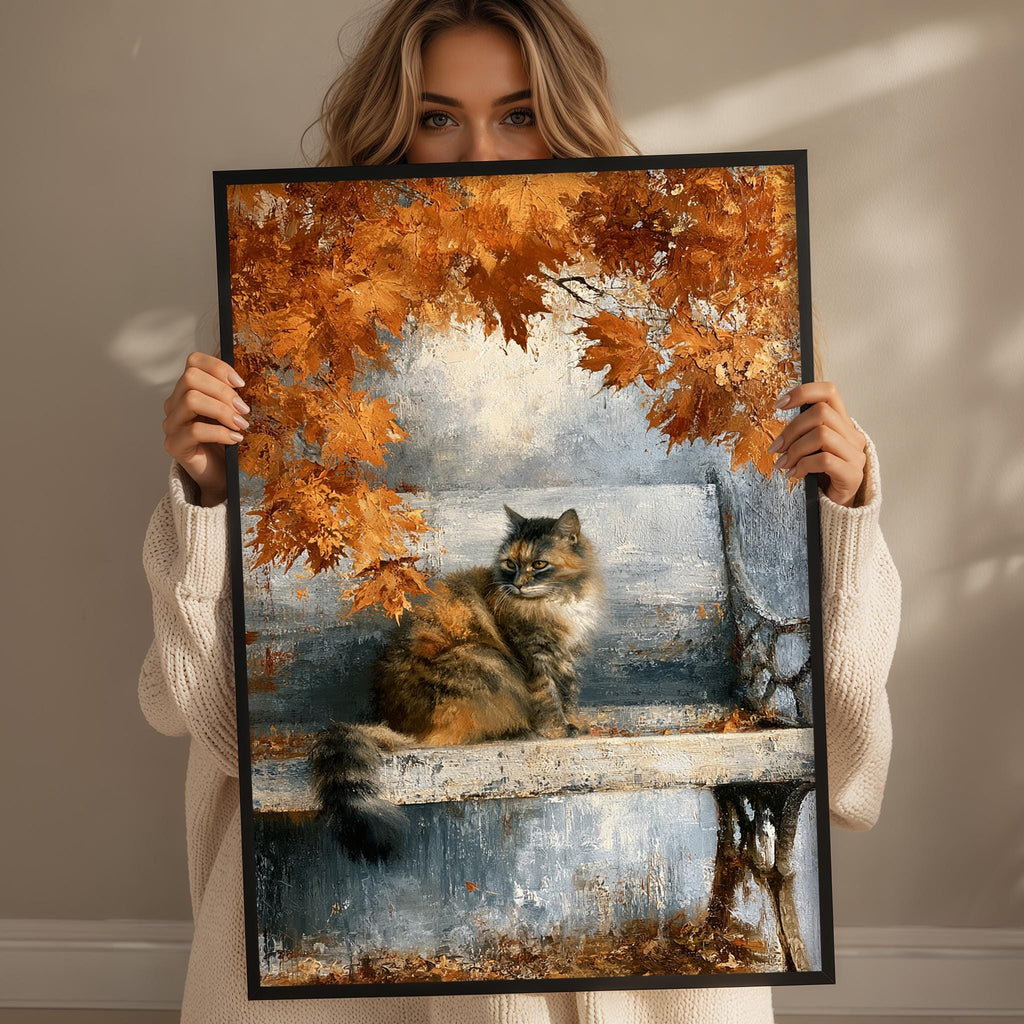 A woman holds up a framed painting depicting a cat sitting on a bench surrounded by autumn leaves.