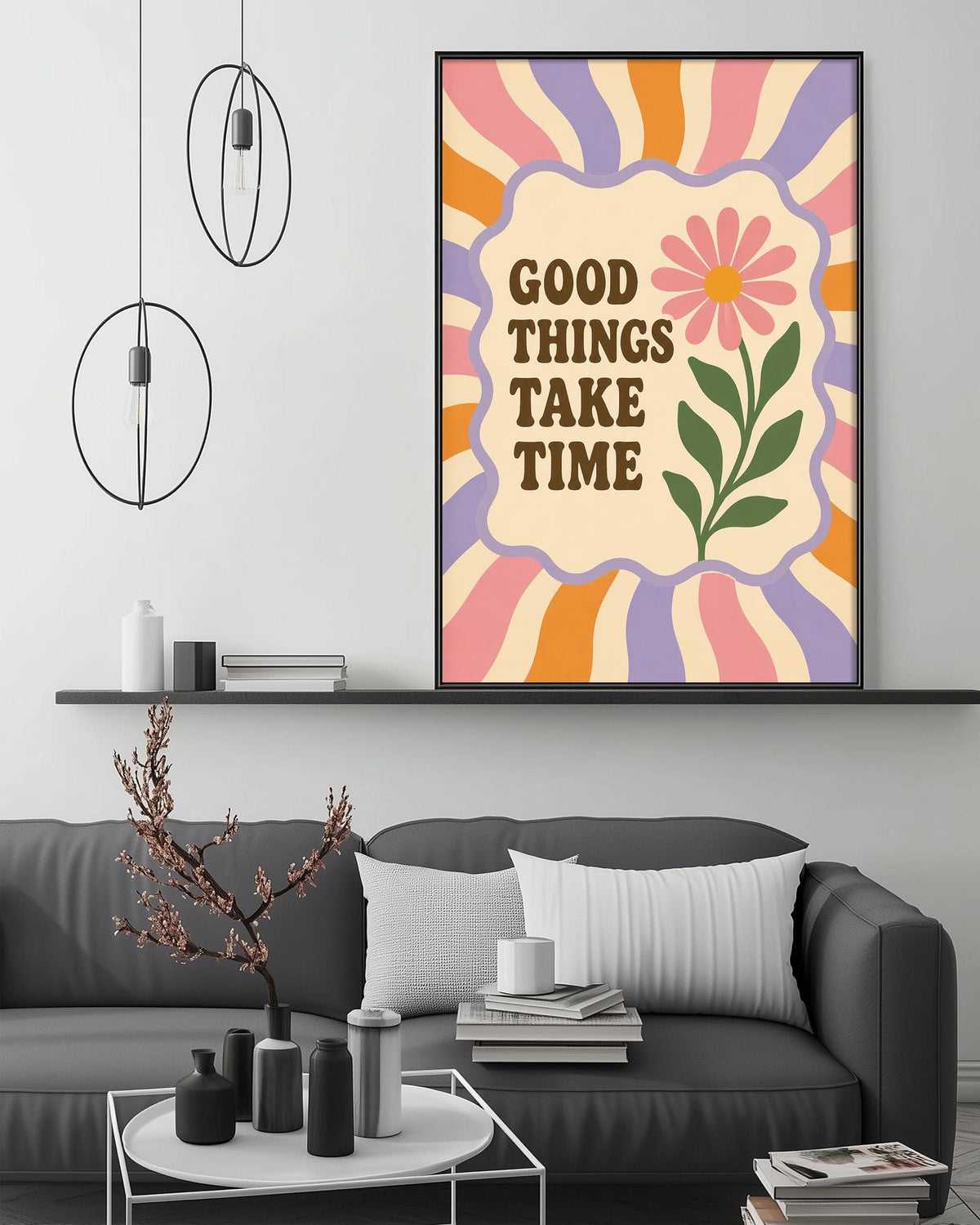 a living room with a gray couch, a coffee table, and a framed poster with a flower and the text "Good things take time" on the wall above it.