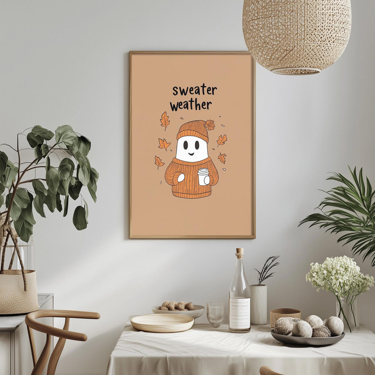 a cozy dining area with a table set for a meal, a potted plant, and a framed poster with a ghost wearing a sweater and holding a cup.