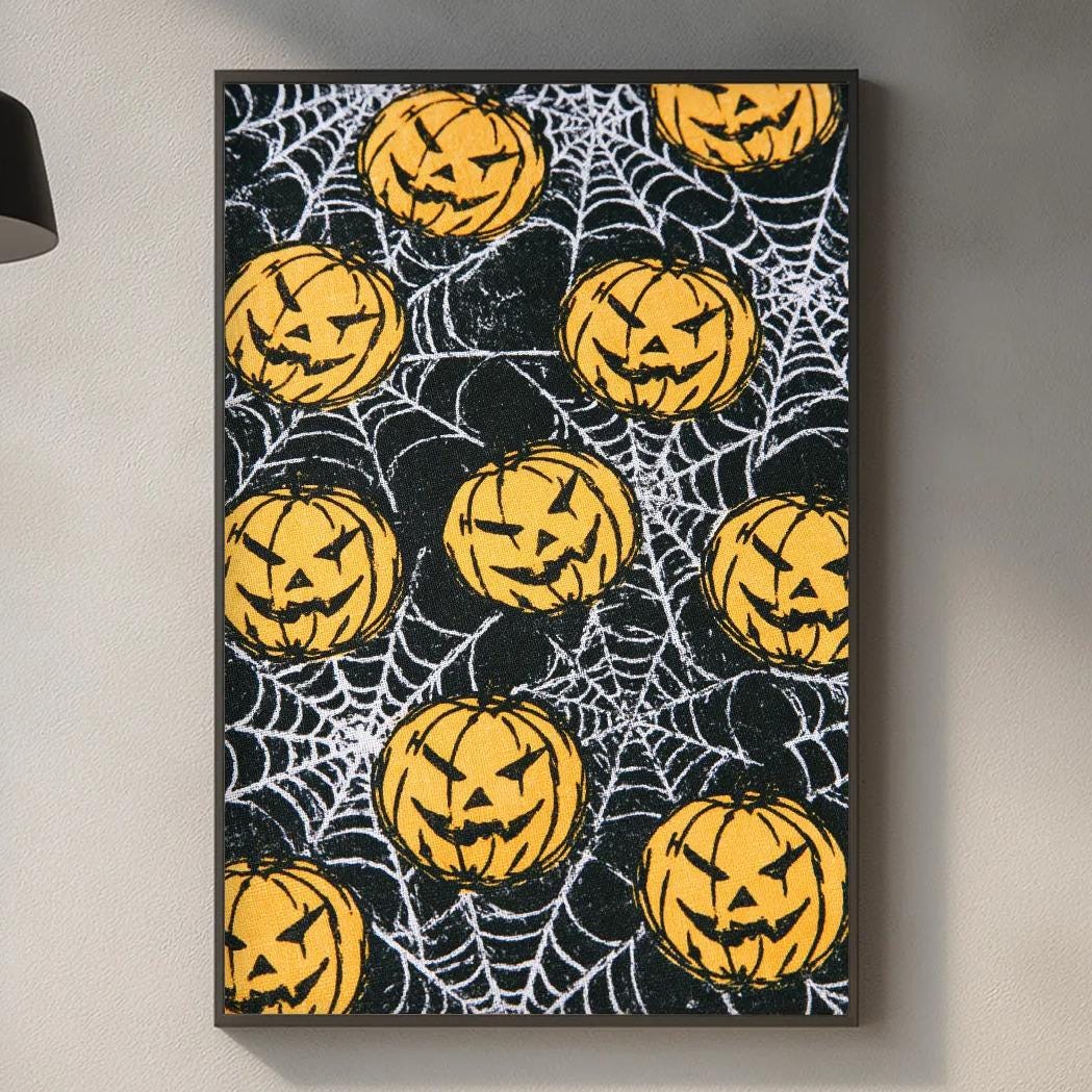 a kitchen counter with a Halloween-themed painting hanging on the wall above it. The painting displays a pattern of jack-o-lanterns and spiderwebs, creating a festive and spooky atmosphere.