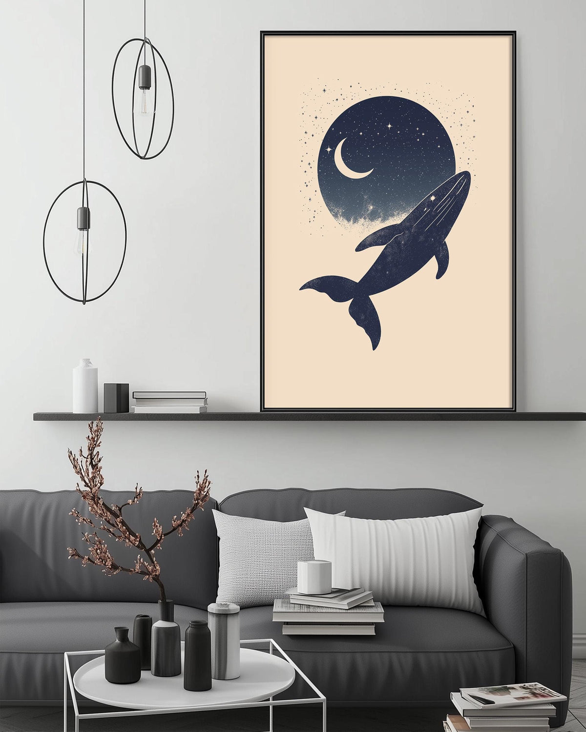 a living room with a gray sofa, a coffee table, and a framed artwork depicting a whale against a night sky with a crescent moon.