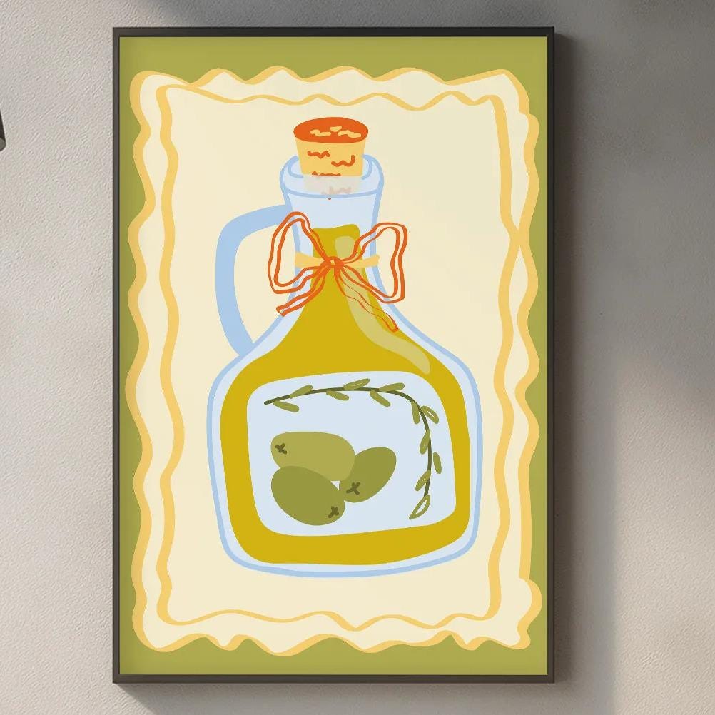 a kitchen counter with various kitchen items, including a framed illustration of a bottle of olive oil, a wooden cutting board, and a potted plant.