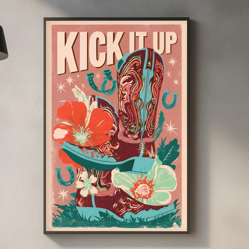 a kitchen counter with various items such as a cutting board, a soap dispenser, and a plant. Above the counter, there is a framed poster with the text "KICK IT UP" and an illustration of a cowboy boot surrounded by flowers and plants.