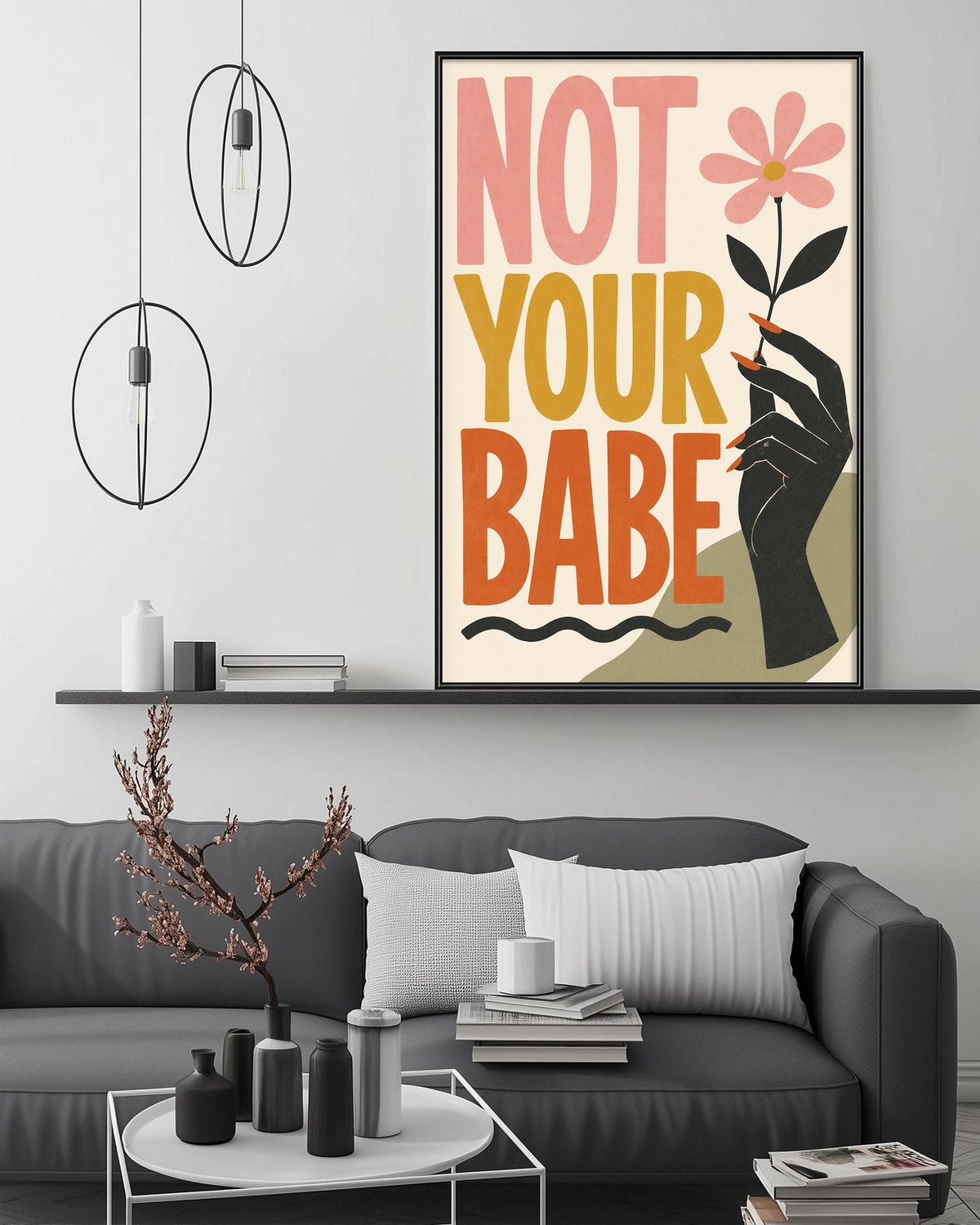 a modern living room with a gray sofa, a coffee table, and a framed poster with a bold statement.