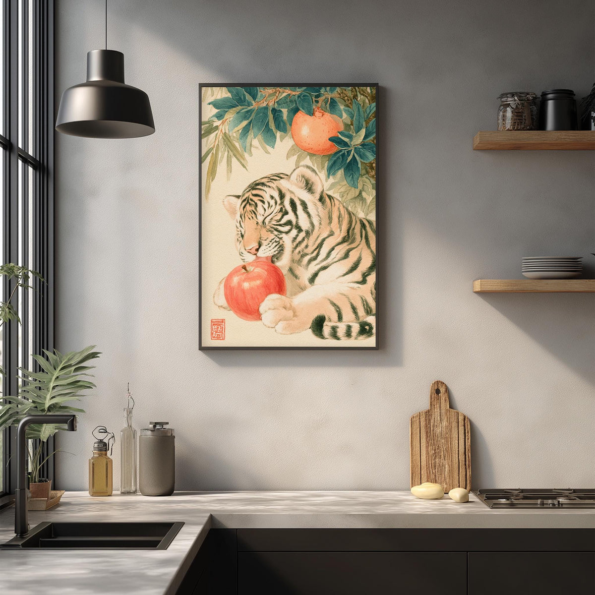 a kitchen counter with a framed painting of a tiger resting on an apple, surrounded by various kitchen items such as a cutting board, a bottle, and a bowl.