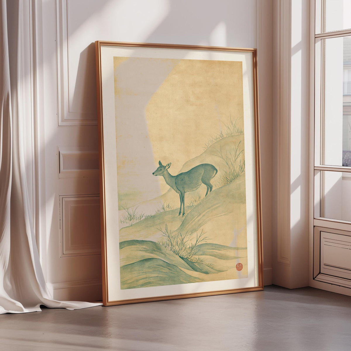 a large framed painting of a deer standing on a hill, with a pale yellow background and green foliage.