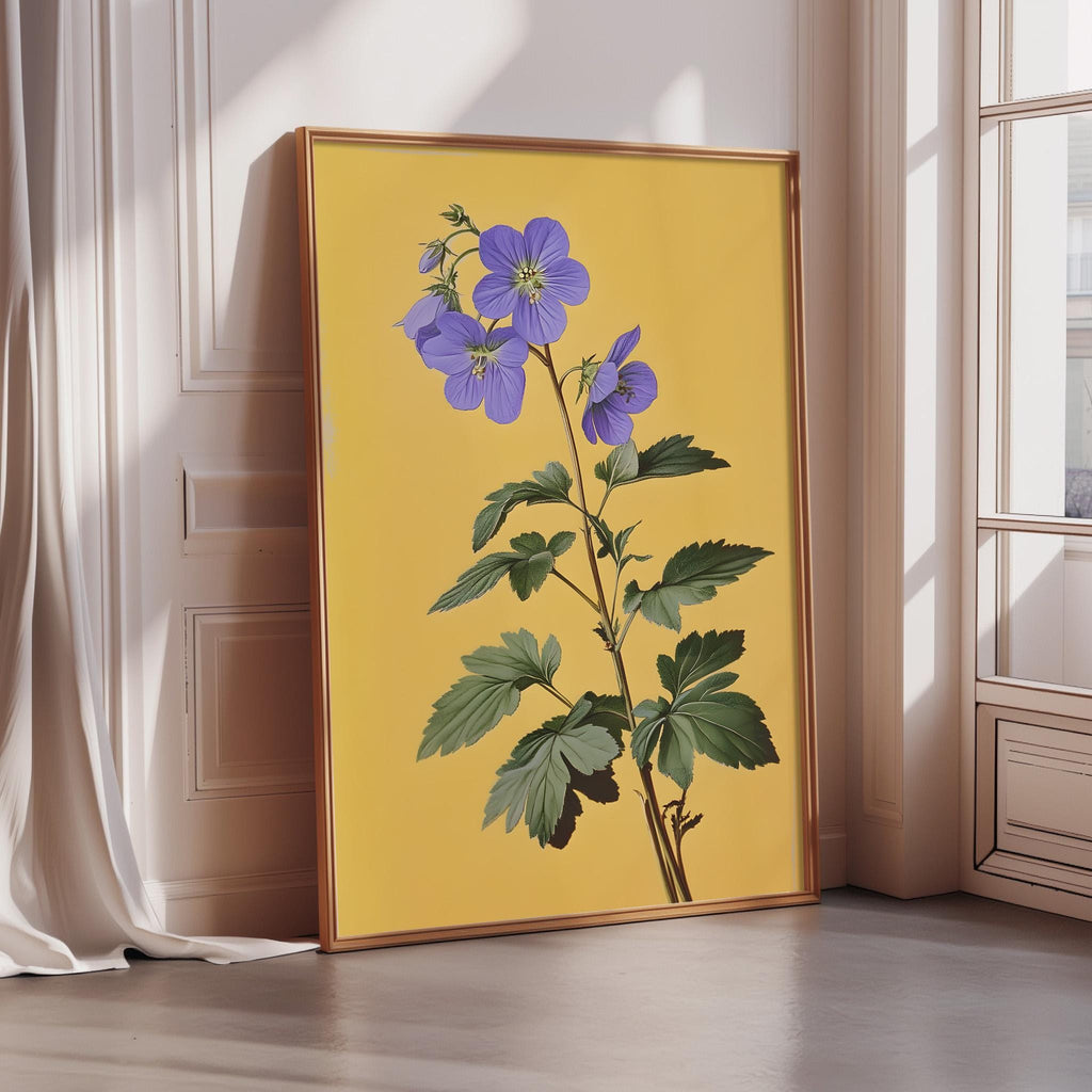A framed illustration of a purple flower on a yellow background, placed on a wooden floor in a room with a window.