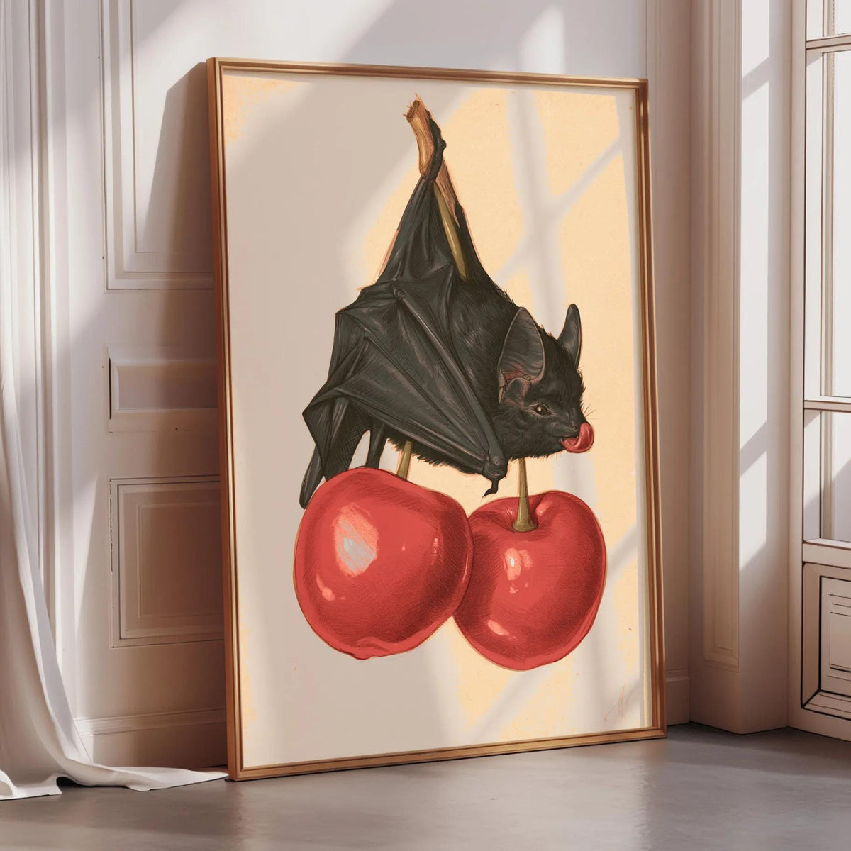 a framed illustration of a bat perched on two red cherries.