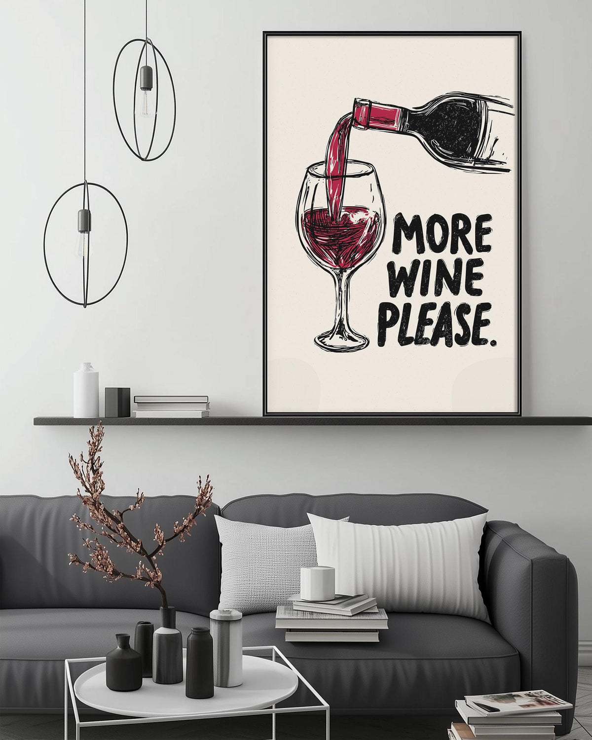 a living room with a gray couch, a coffee table, and a framed poster on the wall that says "MORE WINE PLEASE".