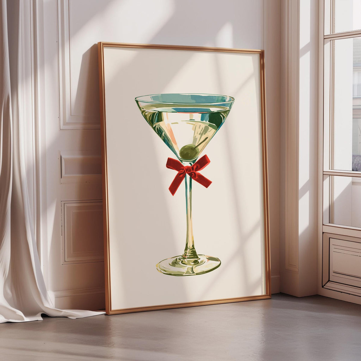 A framed print of a martini glass with a green olive garnish and a red ribbon is displayed on a wall.