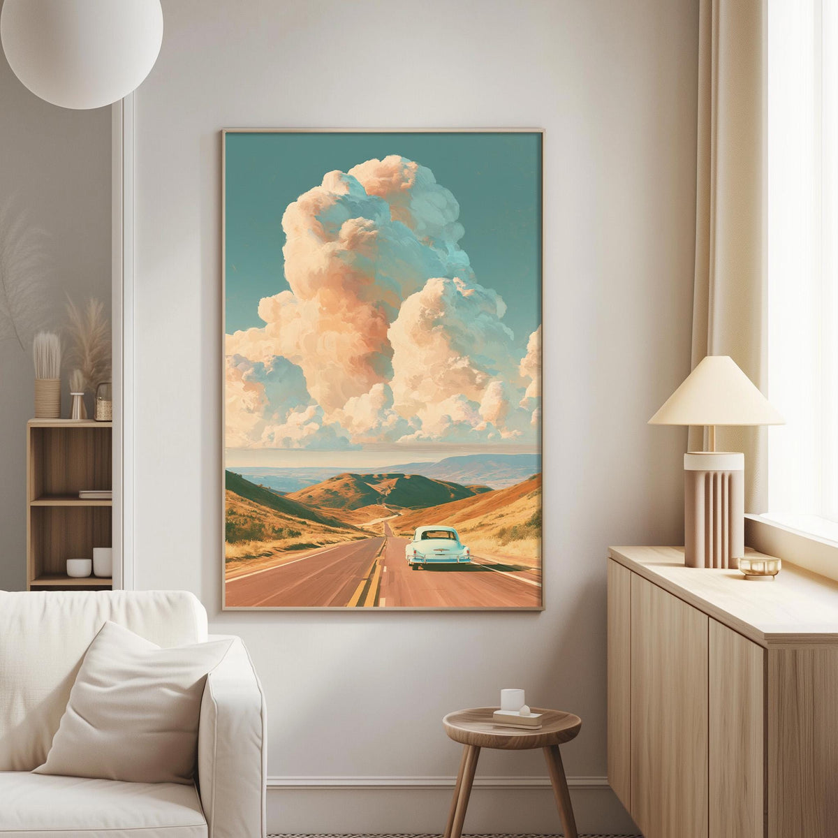 a large framed painting of a car driving on a road through a mountainous landscape with a cloudy sky in the background.