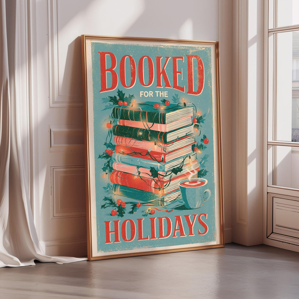 A framed poster with the text "BOOKED FOR THE HOLIDAYS" and an illustration of a stack of books with a cup of tea on top.