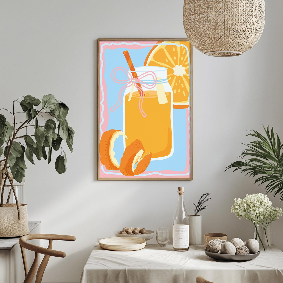 a dining table with a white tablecloth, a vase of flowers, a bottle of wine, and a framed illustration of a glass of orange juice with a slice of orange.