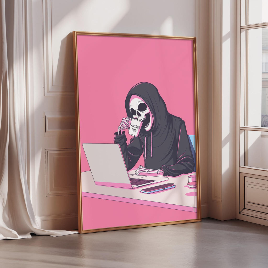 A framed illustration of a skeleton wearing a hooded sweatshirt and holding a coffee mug, sitting at a desk and using a laptop computer.