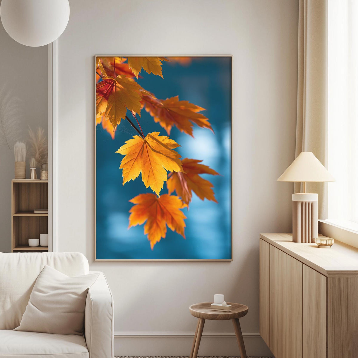 a large framed picture of vibrant orange and yellow autumn leaves hanging on a wall in a cozy living room setting.