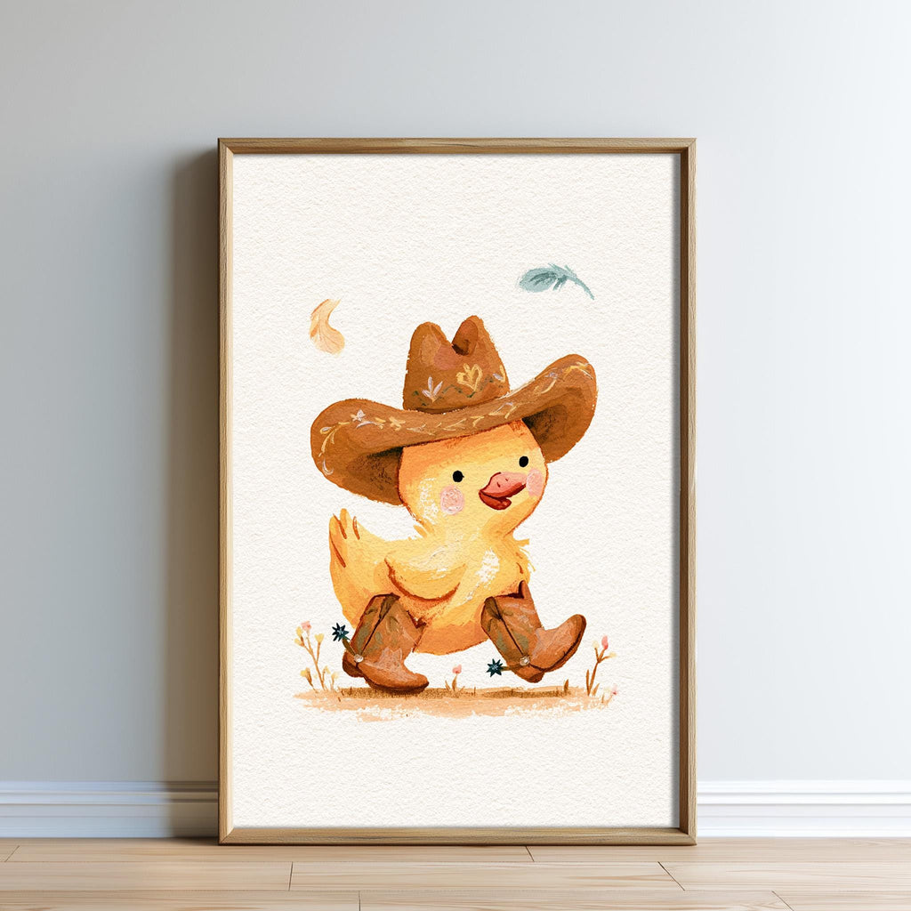 A framed illustration of a yellow duck wearing a cowboy hat and boots, standing on a grassy field with a feather in the air.