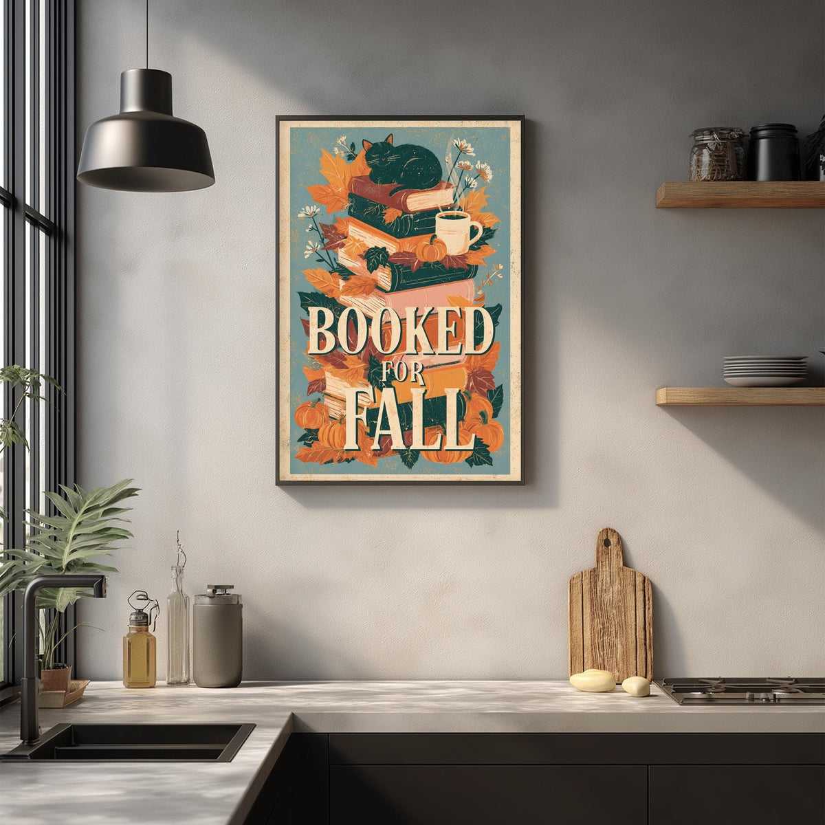 a kitchen counter with various items, including a framed poster with a cat and autumn leaves, a wooden cutting board, and a potted plant.