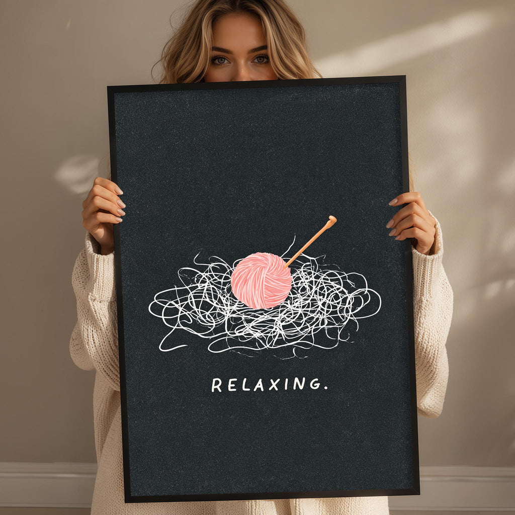 A woman holding a black poster with a pink ball of yarn and a crochet hook on it, along with the word "Relaxing" written below.