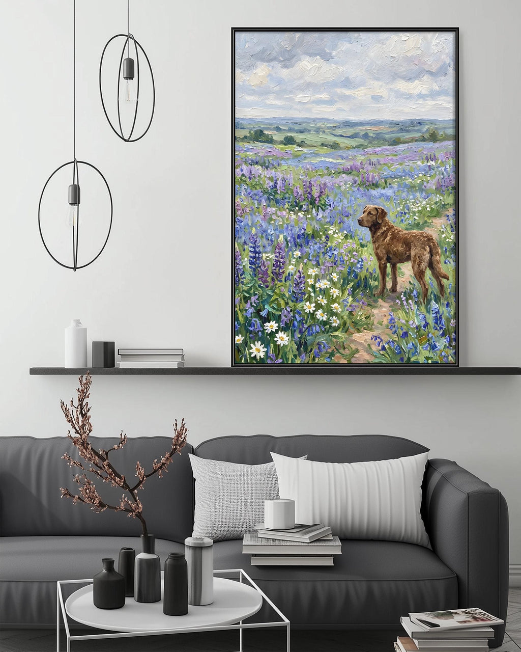 a large painting of a dog standing in a field of flowers, with a serene landscape in the background. The painting is hung on a wall above a gray couch, which has a coffee table in front of it. The room also includes a shelf with decorative items and a potted plant.