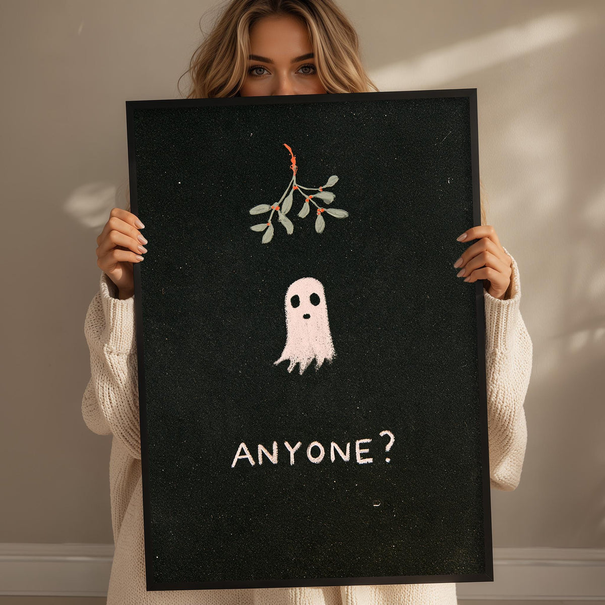 A woman holding a black poster with a ghost and the text "ANYONE?"