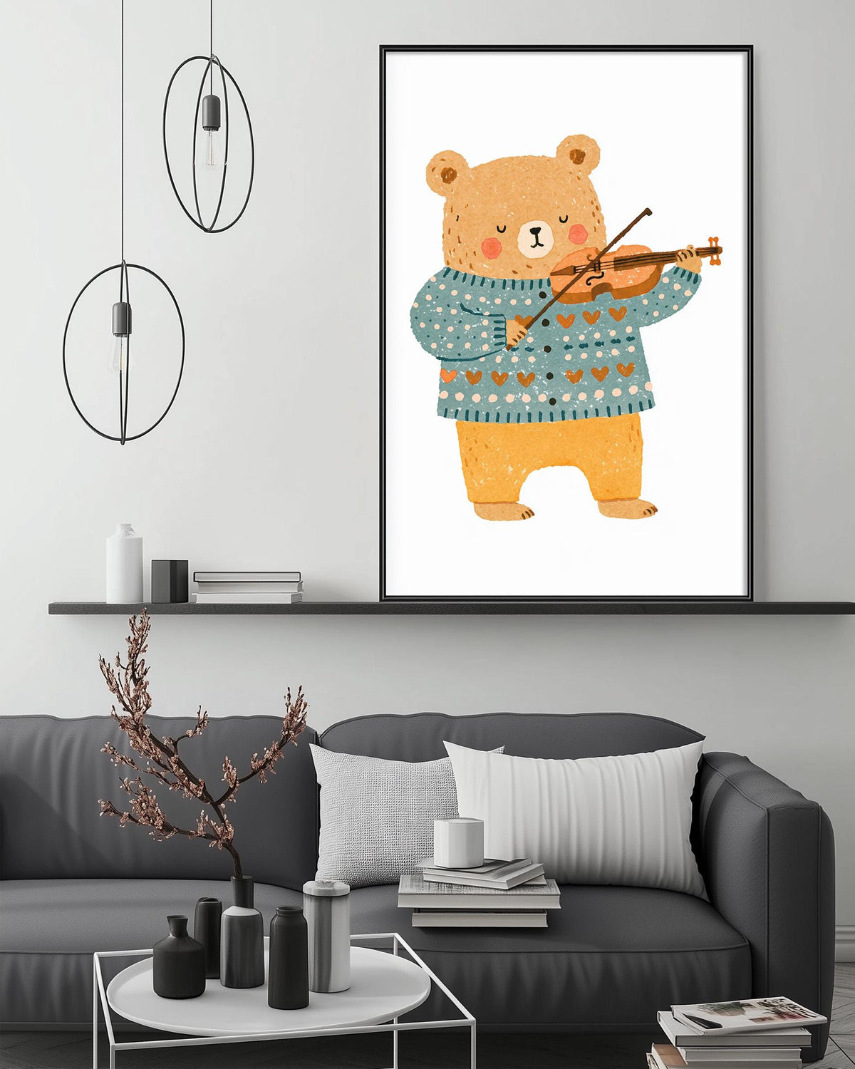 a cozy living room with a gray couch, a coffee table, and a framed illustration of a bear playing a violin. The room has a minimalist and modern design, with a white wall and a shelf displaying decorative items.