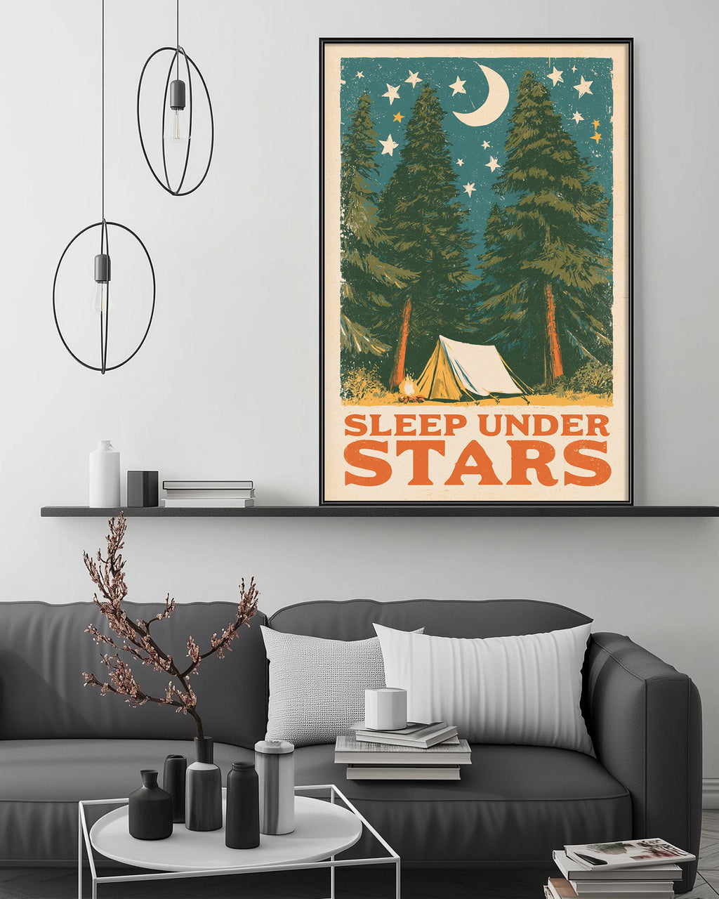 a cozy living room with a gray sofa, a coffee table, and a framed poster of a camping scene with a crescent moon and stars above it.