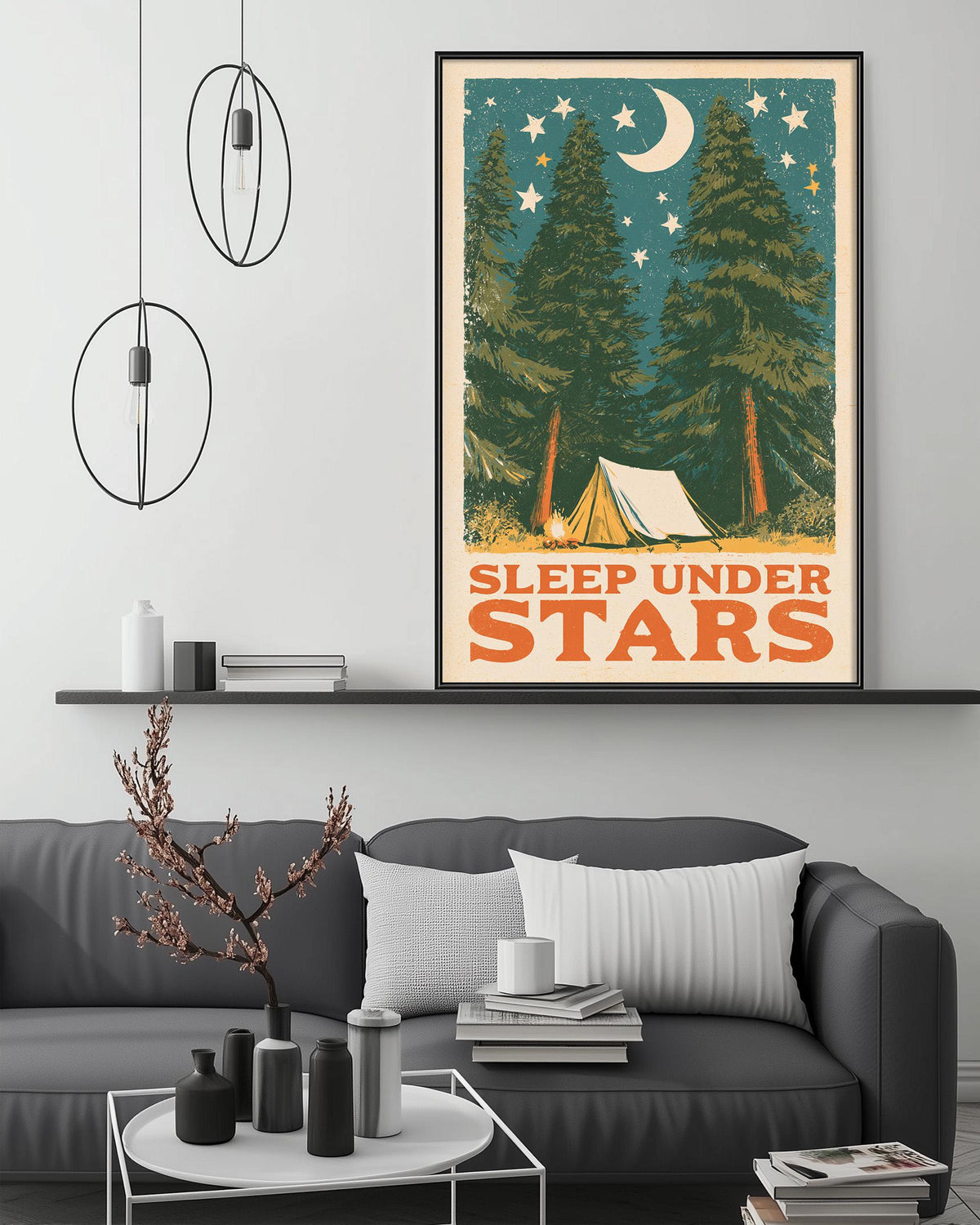 a cozy living room with a gray sofa, a coffee table, and a framed poster of a camping scene with a crescent moon and stars above it.