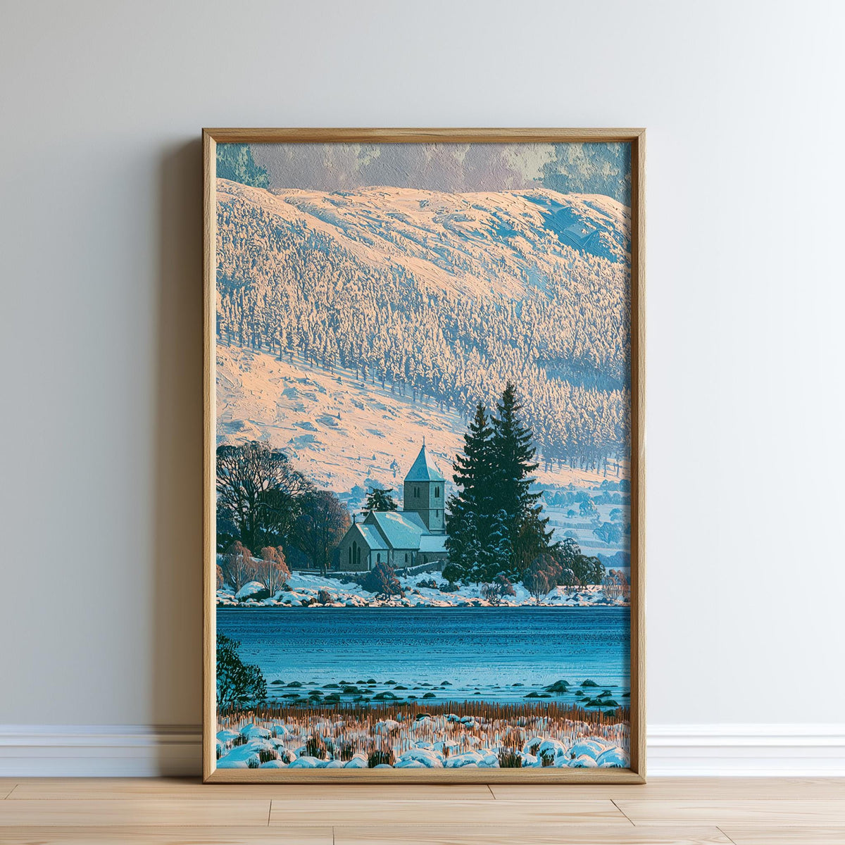 A framed photograph depicting a serene winter landscape with a church, trees, and a body of water.