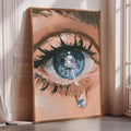 a large, framed painting depicting a close-up of a human eye with a tear streaming down its surface.