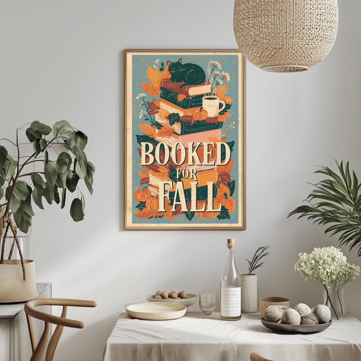 a framed poster with the text "BOOKED FOR FALL" hanging on a wall above a dining table with various items on it.