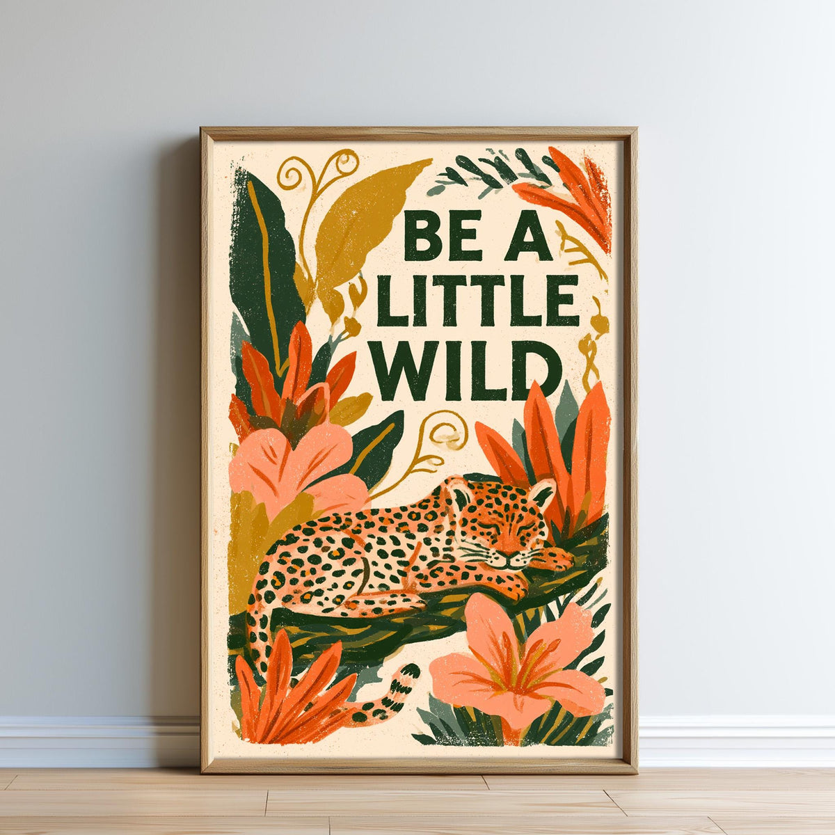 The image is a framed poster with a leopard and various tropical plants, including flowers and leaves, along with the text "Be a little wild".